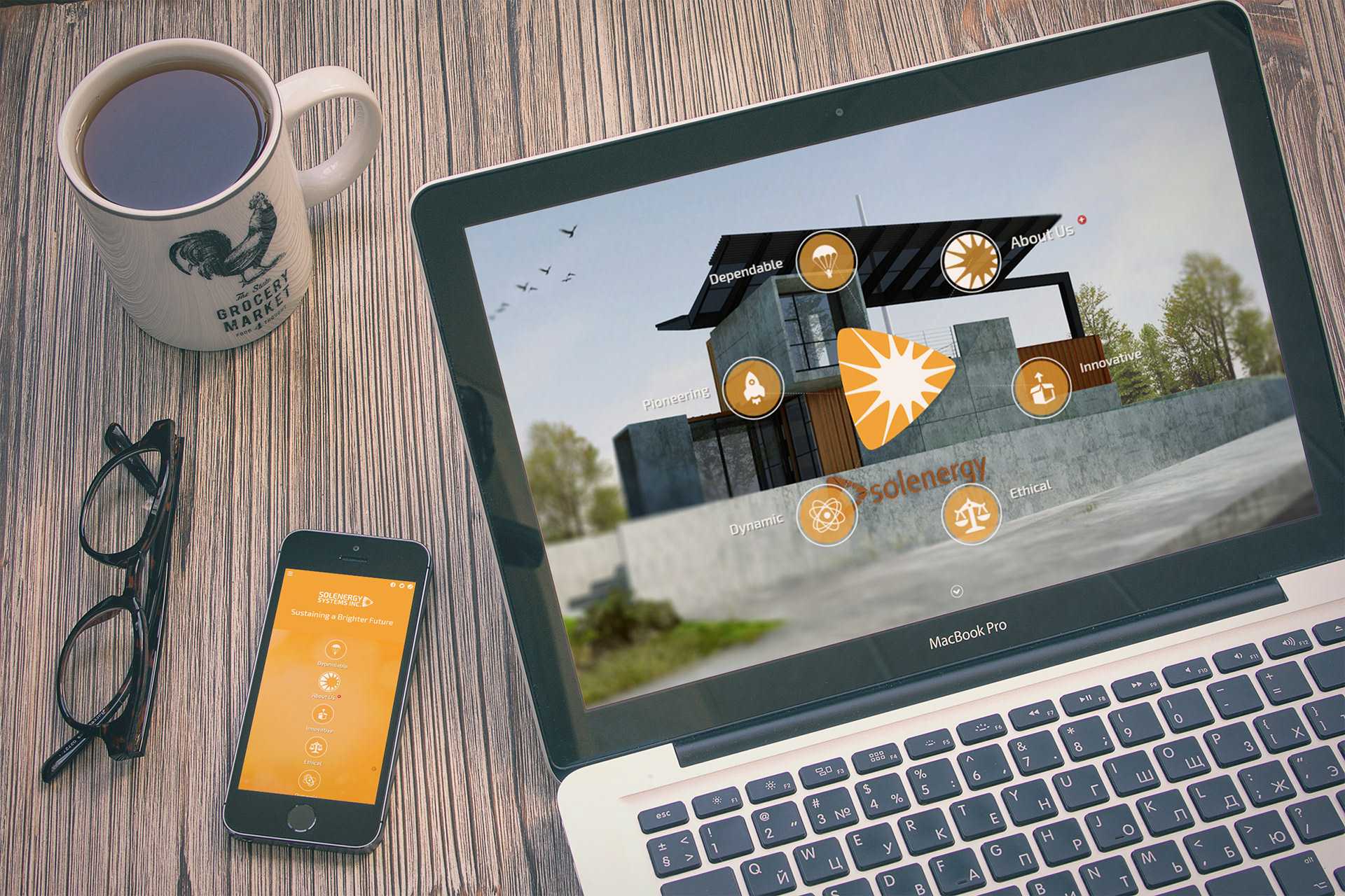 Solenergy website shown on a laptop and phone mockup on a desk, displaying the animated About Us icons and the mobile layout
